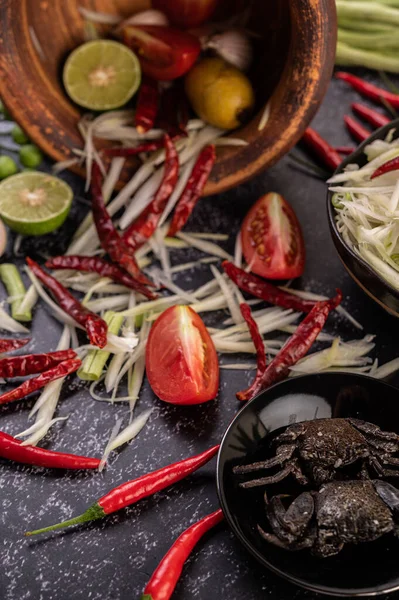 Papaya salatası malzemeleri arasında papaya, turşulu yengeç, patlıcan, domates, ıhlamur, biber, sarımsak ve mayalanmış balık yer alıyor..