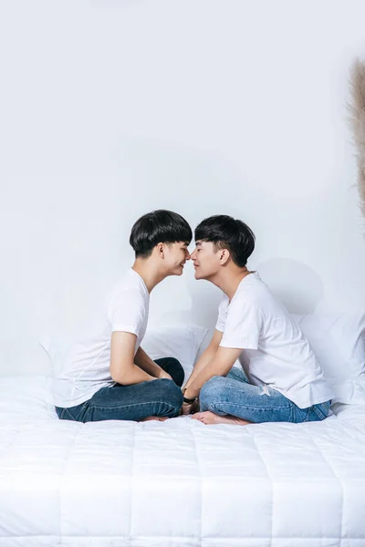 Sevgili Genç Adam Yatakta Oturmuş Ele Tutuşuyor Birbirlerine Bakıyorlardı — Stok fotoğraf