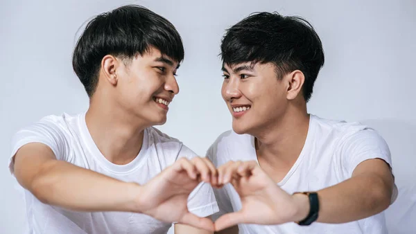 二人の愛の若い男性がお互いを見て 愛のシンボルの手を作る — ストック写真