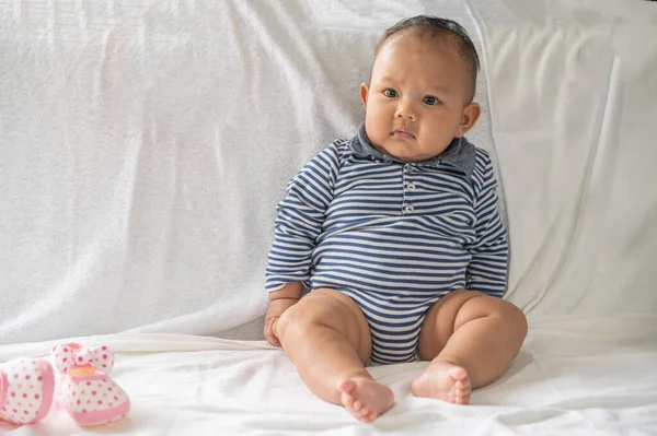 Vauva Oppii Istumaan Valkoisella Sängyllä — kuvapankkivalokuva