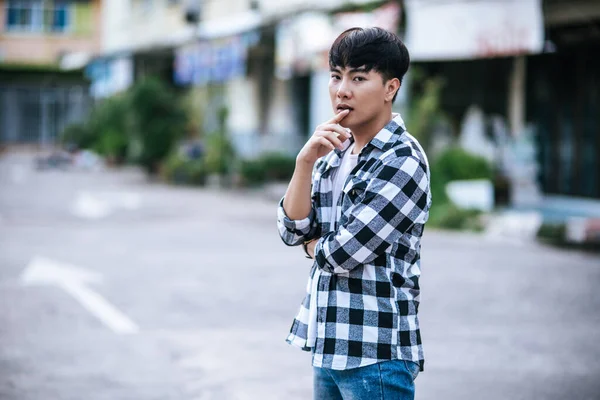 Çizgili Tişörtlü Genç Bir Adam Sokakta Dikiliyor — Stok fotoğraf