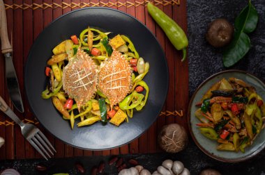 Dolmalık biberli ve domatesli tabakta köri tozlu kızarmış yengeç..