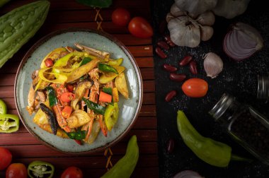 Dolmalık biberli ve domatesli tabakta köri tozlu kızarmış yengeç..