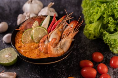 Tom karides, yengeç, limon, kırmızı biber, domates, sarımsak, limon otu ve kaffir limon yapraklı..