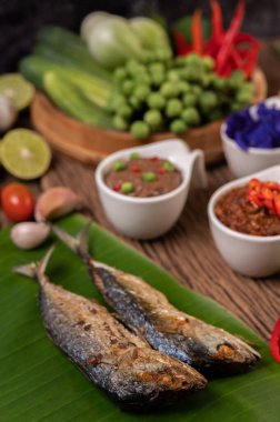 Karides ezmesi, uskumru, muz yaprakları, acı biber, domates, ahşap zeminde sarımsak ve limon..