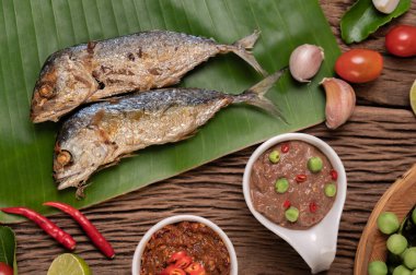 Karides ezmesi, uskumru, muz yaprakları, acı biber, domates, ahşap zeminde sarımsak ve limon..