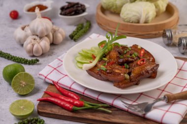 Pirzola, biber, limon, salatalık, domates ve sarımsaklı beyaz bir tabakta tatlı domuz eti..