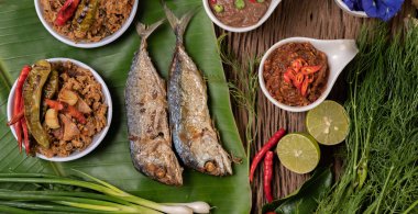 Karides ezmesi, uskumru, muz yaprakları, acı biber, domates, ahşap zeminde sarımsak ve limon..