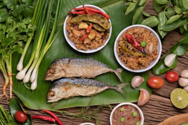 Karides ezmesi, uskumru, muz yaprakları, acı biber, domates, ahşap zeminde sarımsak ve limon..