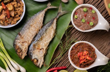 Karides ezmesi, uskumru, muz yaprakları, acı biber, domates, ahşap zeminde sarımsak ve limon..