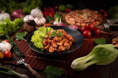 Kırmızı soğanlı Larb Sausage ve siyah tabakta marul. Seçici odak.