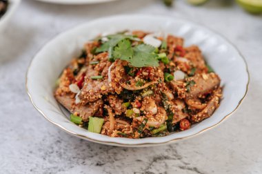 Acı biberli domuz ciğeri salatası, kızarmış pirinç, taze soğan, havuç ve salatalık..