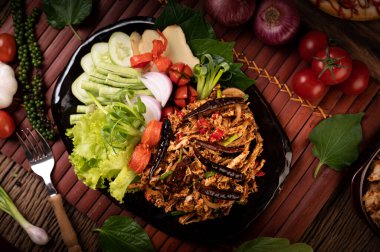 Tavuklu Larb tabakta kurutulmuş biber, domates, taze soğan ve marul..