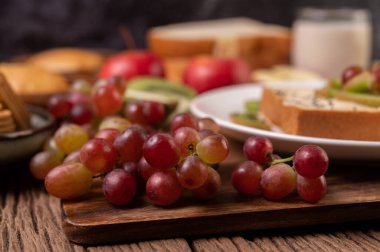 Tahta masadaki kesme tahtasındaki üzümler. Seçici odak.