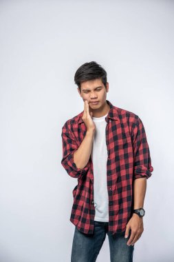 Diş ağrısı ve yanağında bir el olan hasta bir adam.