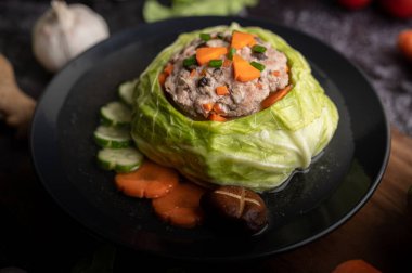 Havuçlu lahana çorbası, doğranmış yeşil soğan, ahşap tabakta salatalık..