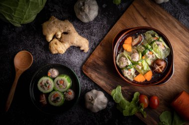 Havuçlu lahana çorbası, doğranmış yeşil soğan, ahşap tabakta salatalık..