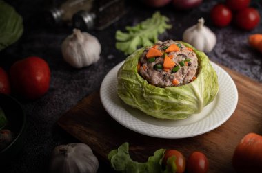 Havuçlu lahana çorbası, doğranmış yeşil soğan, ahşap tabakta salatalık..