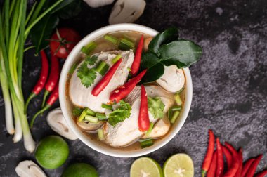 Acı biberli, kişniş, kurutulmuş acı biber, kaffir limon yaprağı, mantar ve limon otlu bir kase.