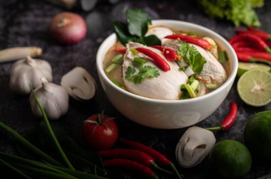 Acı biberli, kişniş, kurutulmuş acı biber, kaffir limon yaprağı, mantar ve limon otlu bir kase.