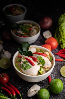 Acı biberli, kişniş, kurutulmuş acı biber, kaffir limon yaprağı, mantar ve limon otlu bir kase.