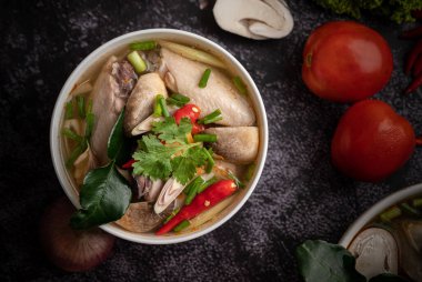 Acı biberli, kişniş, kurutulmuş acı biber, kaffir limon yaprağı, mantar ve limon otlu bir kase.