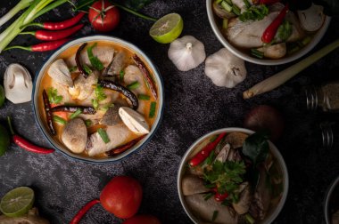 Acı biberli, kişniş, kurutulmuş acı biber, kaffir limon yaprağı, mantar ve limon otlu bir kase.