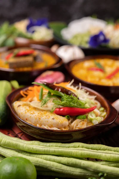 Pirinç eriştesi, köfteli kırmızı köri, kurutulmuş biber, fesleğen, salatalık ve uzun fasulye.