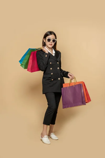 这个女人穿着黑色的衣服 戴着黑色的眼镜 还带着许多袋子去购物 — 图库照片