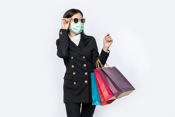 那位年轻妇女身穿黑色衣服 戴着面具 戴着眼镜和提包去购物 — 图库照片