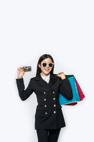 戴黑眼镜 带信用卡和很多包的女人 — 图库照片