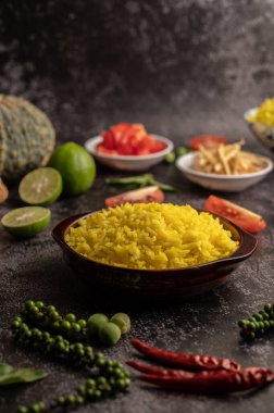 Kahverengi bir fincanda siyah çimento üzerinde baharatlar olan zerdeçal pilavı..