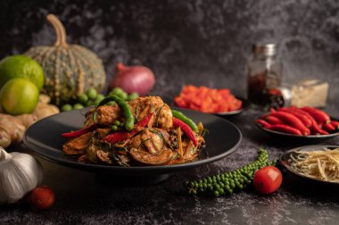 Siyah tabakta kızartılmış baharatlı yayın balığı ve siyah çimentoda baharatlar..