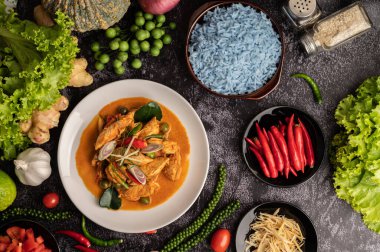 Siyah çimentoda beyaz tabakta tavuklu kuru yeşil köri.