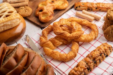 Kırmızı beyaz kumaş üzerinde çeşitli ekmekler. Seçici odak.