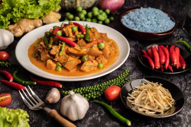 Beyaz tabakta kırmızı köri ve siyah çimentoda baharatlar..