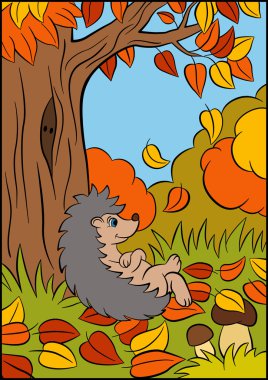 Küçük sevimli kirpi büyük ağacın yanında yatıyor. Sonbahar.