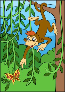 Küçük sevimli maymun ağaç üzerinde asılı ve butterfly'görünüyor