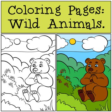 Küçük sevimli ayı çimenlerin üzerinde oturur ve çilek görünüyor.