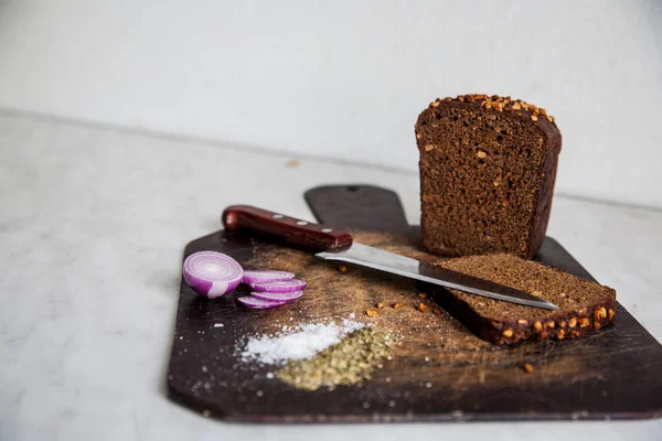 Chlebem a cibulí na bourání desky izolované sůl — Stock fotografie