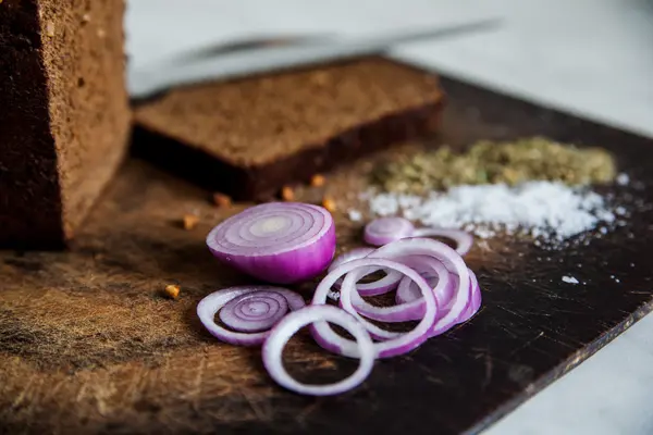 Bread and onions on a cutting board isolated salt — Stock Photo, Image