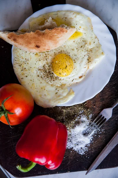 Closeup της πλάκας με τηγανητά αυγά και ντομάτες κοντά πηρούνι και μαχαίρι — Φωτογραφία Αρχείου