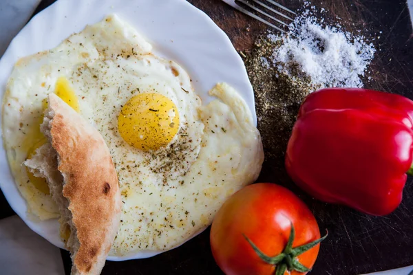 Zbliżenie płyta smażone jajka i pomidory w pobliżu widelec i nóż — Zdjęcie stockowe