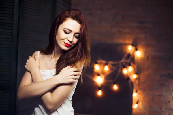 La chica con el pelo rojo contra las luces de fondo —  Fotos de Stock