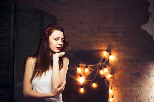 La ragazza con i capelli rossi contro le luci di sfondo — Foto Stock