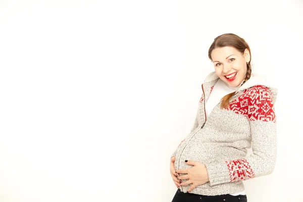 Šťastný, mladá těhotná žena v zimní oblečení na bílém pozadí — Stock fotografie