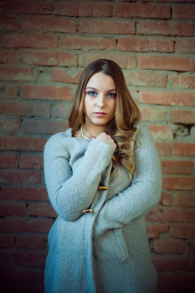 Hermosa chica retrato blanco suéter ladrillo fondo —  Fotos de Stock