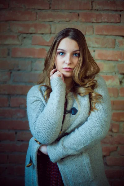 Bela menina retrato branco suéter tijolo fundo — Fotografia de Stock