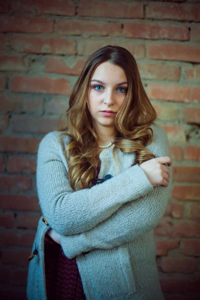 Hermosa chica retrato blanco suéter ladrillo fondo —  Fotos de Stock