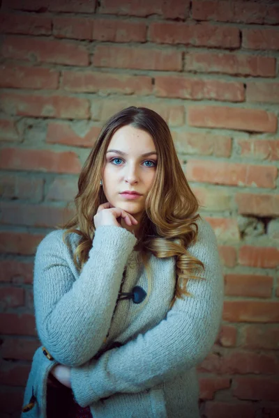 Красивый портрет девушки белый свитер кирпичный фон — стоковое фото